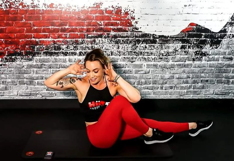 Coach demonstrating a strength movement at HIIT56 West Boca